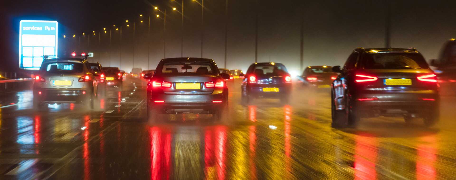 Cars driving at night on a road.