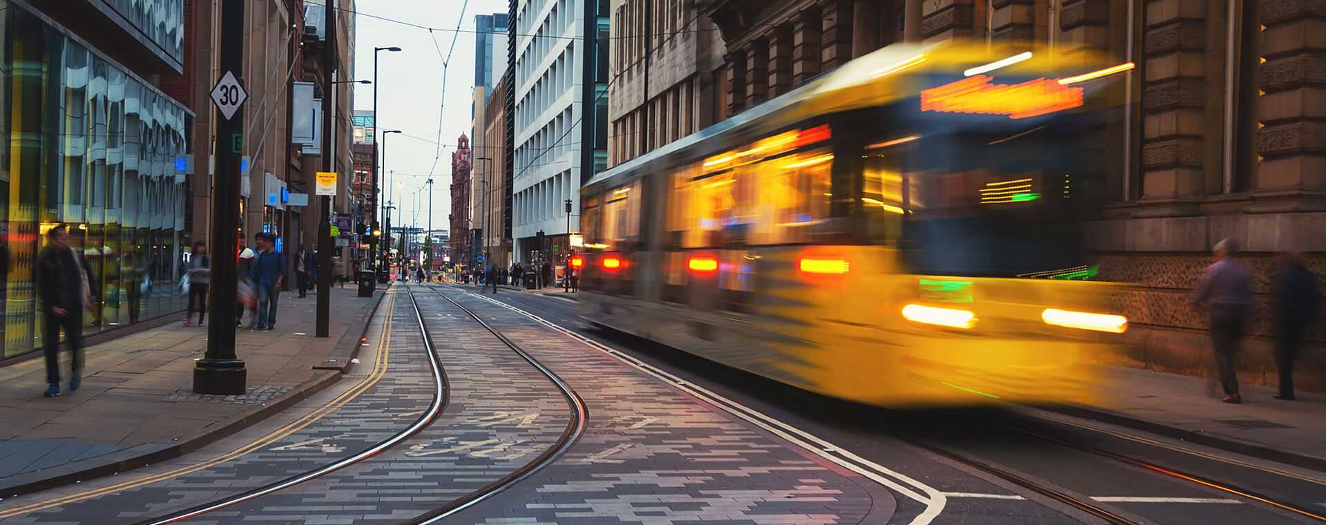 A blurred tram passing through a city