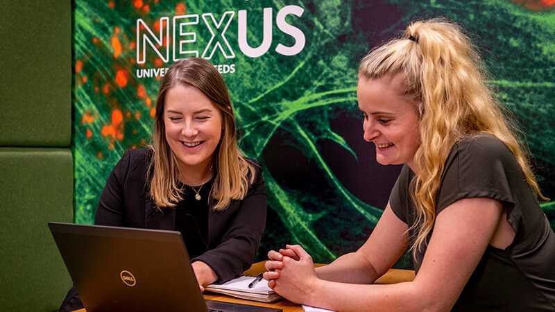 Two employees working around a laptop.